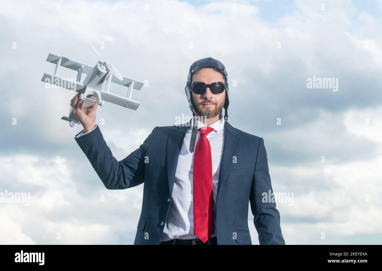 uomo d'affari in tuta e cappello pilota lancio aereo giocattolo. promozione Foto Stock