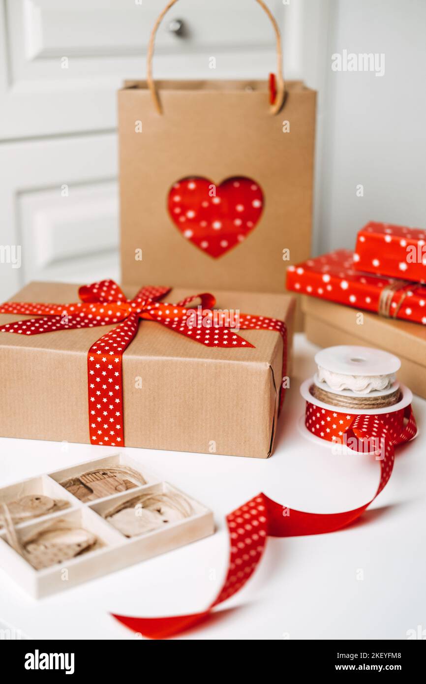 Confezioni regalo di Natale e forniture. Rosso marrone Natale scatola regalo, borsa di carta kraft shopping e nastri per la confezione. Sostenibilità ecologica zero Foto Stock