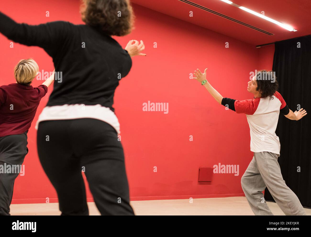 Insegnante di teatro fisico indica il movimento a due studenti che lo imitano Foto Stock