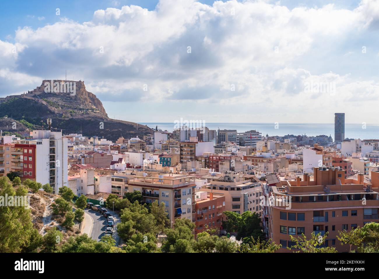 Vista sopraelevata del paesaggio urbano di Alicante con il castello di Santa Barbara sulla cima di una montagna Foto Stock