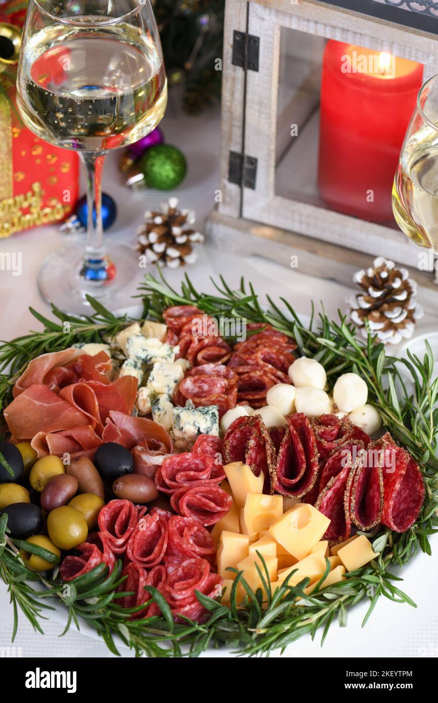 Delicatezza piatto assortito di antipasti di salumi e formaggi, prosciutto di Parma, olive. Un antipasto originale che serve per una festa di Natale. Foto Stock