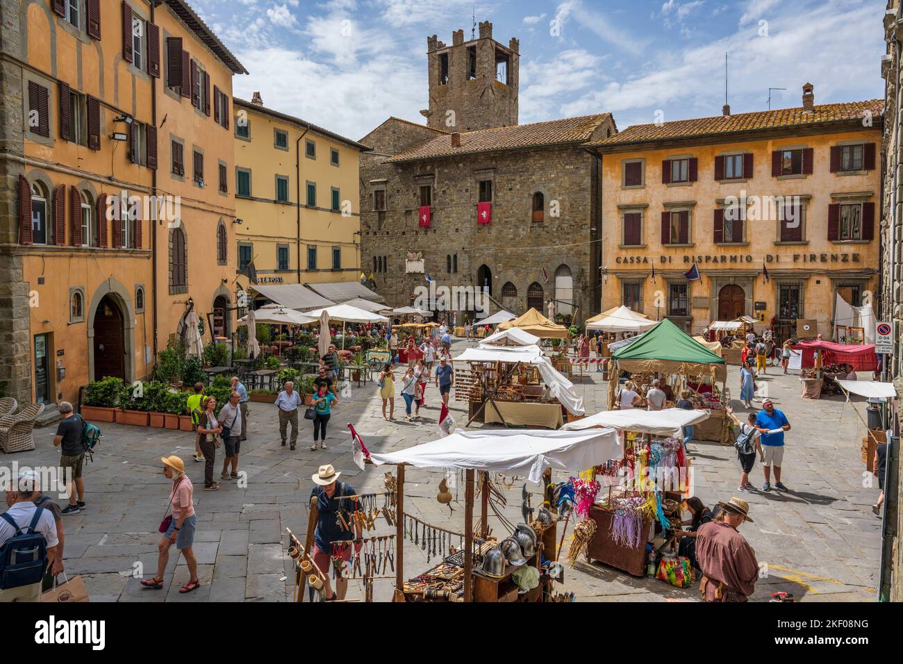 Bancarelle di mercato in Piazza Luca Signorelli con Chiesa evangelica 'i Fratelli' sullo sfondo nella cittadina collinare di Cortona in Toscana Foto Stock