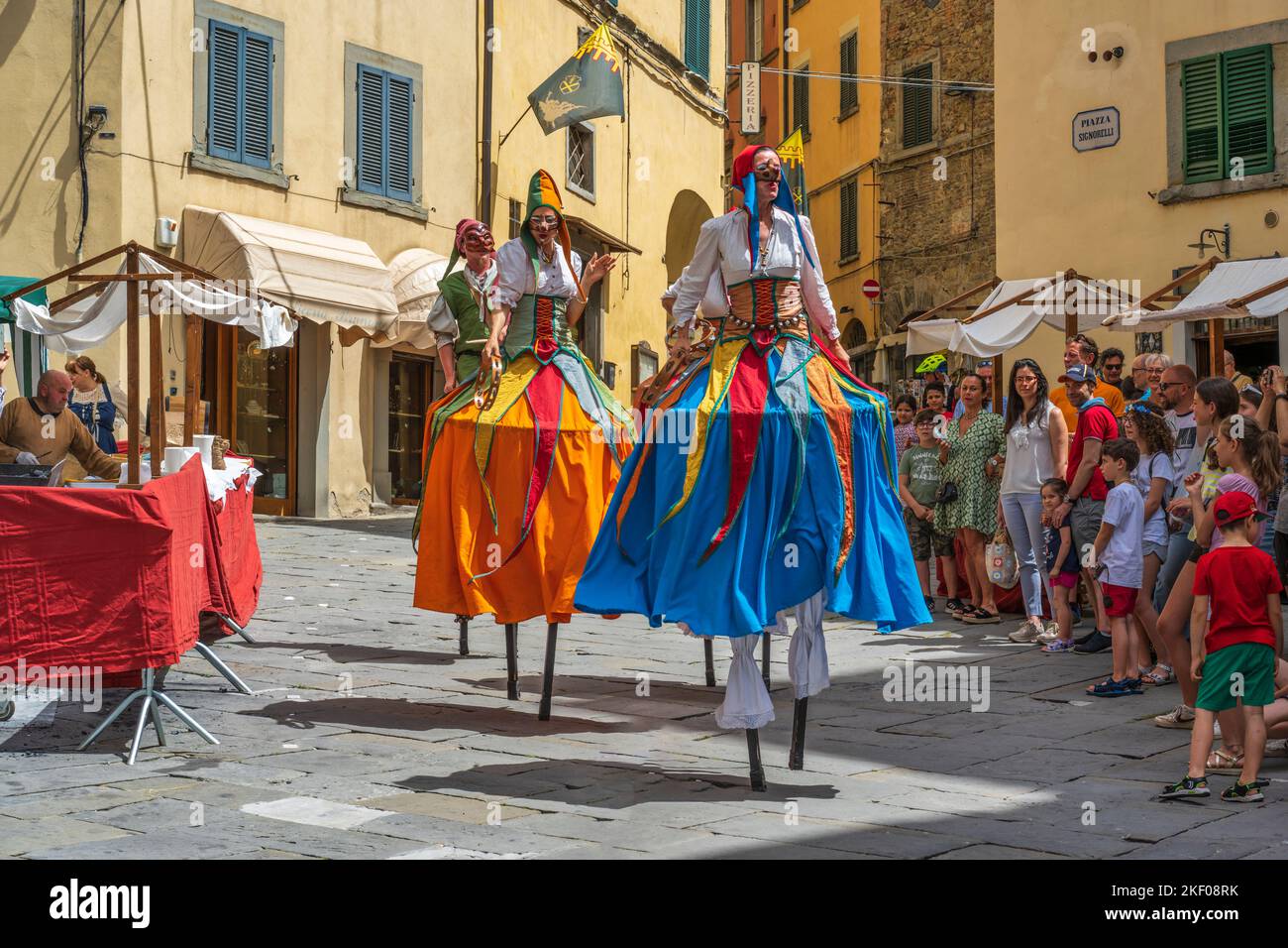 Artisti di strada su palafitte in Piazza Luca Signorelli nella cittadina collinare di Cortona in Toscana Foto Stock