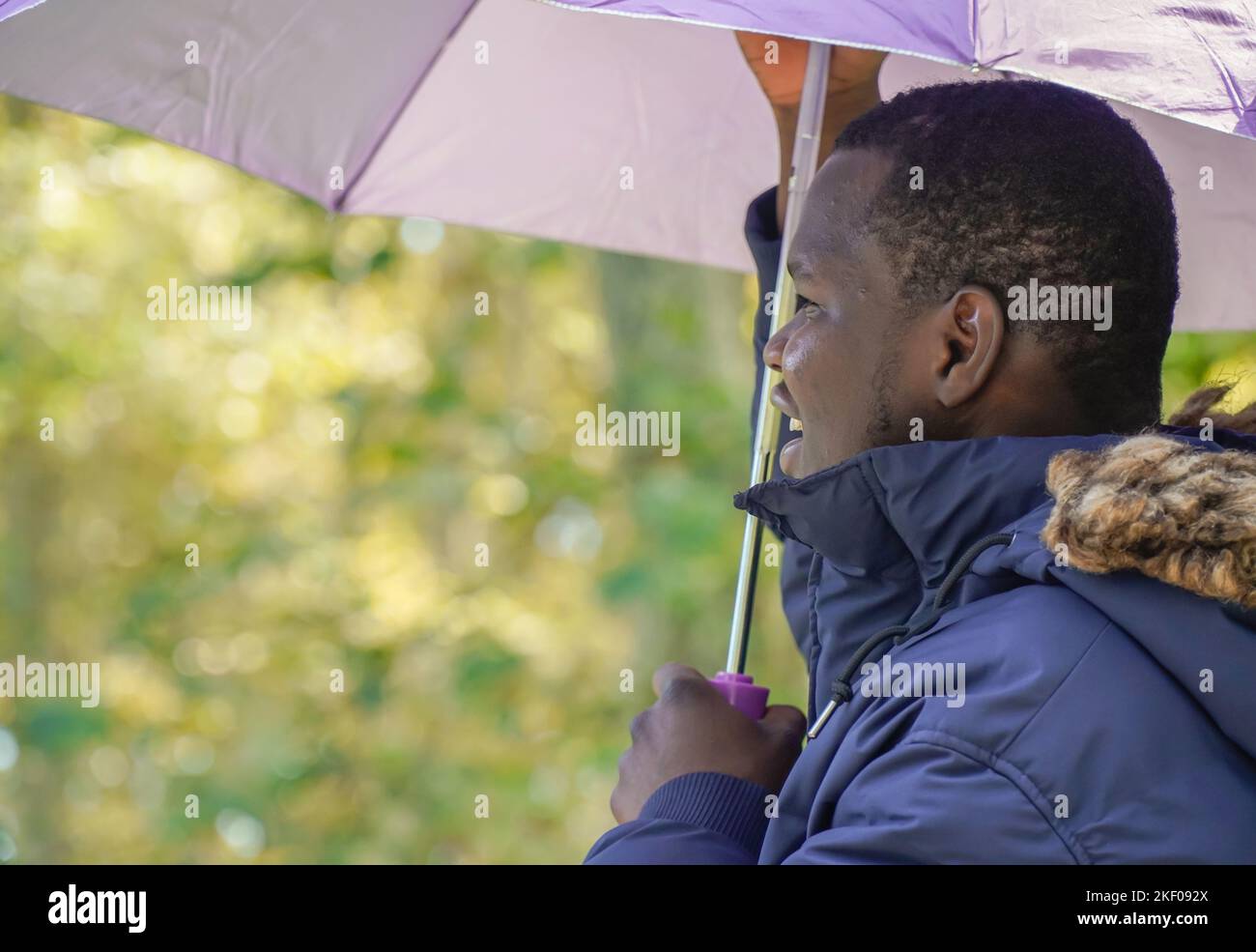 uomo nero africano con ombrello in inverno. migrazione spagnola Foto Stock