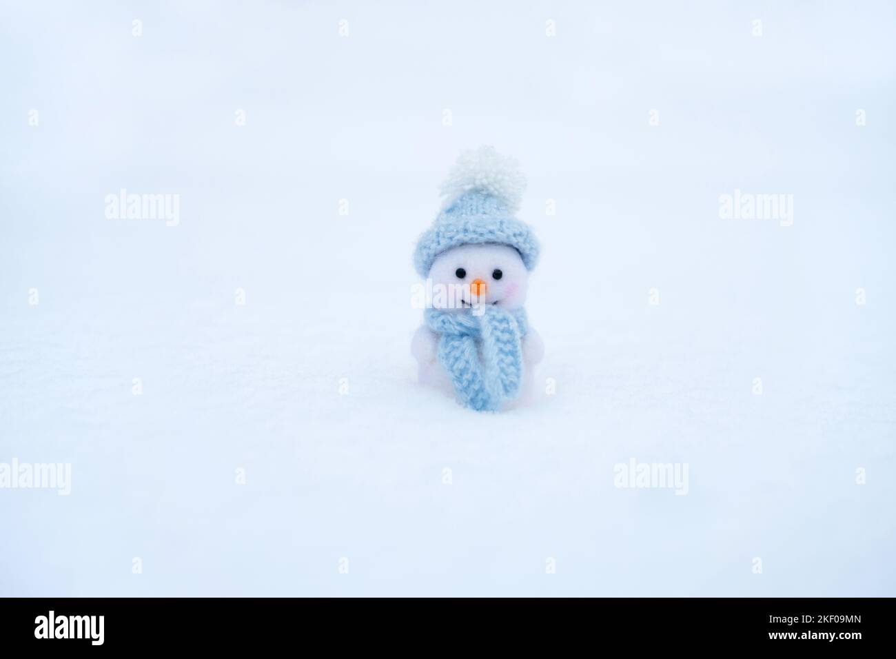 Giocattolo Snowman sullo sfondo della neve invernale. Giocattolo di lana di Natale. Felice Anno Nuovo. Spazio per il testo. Foto Stock