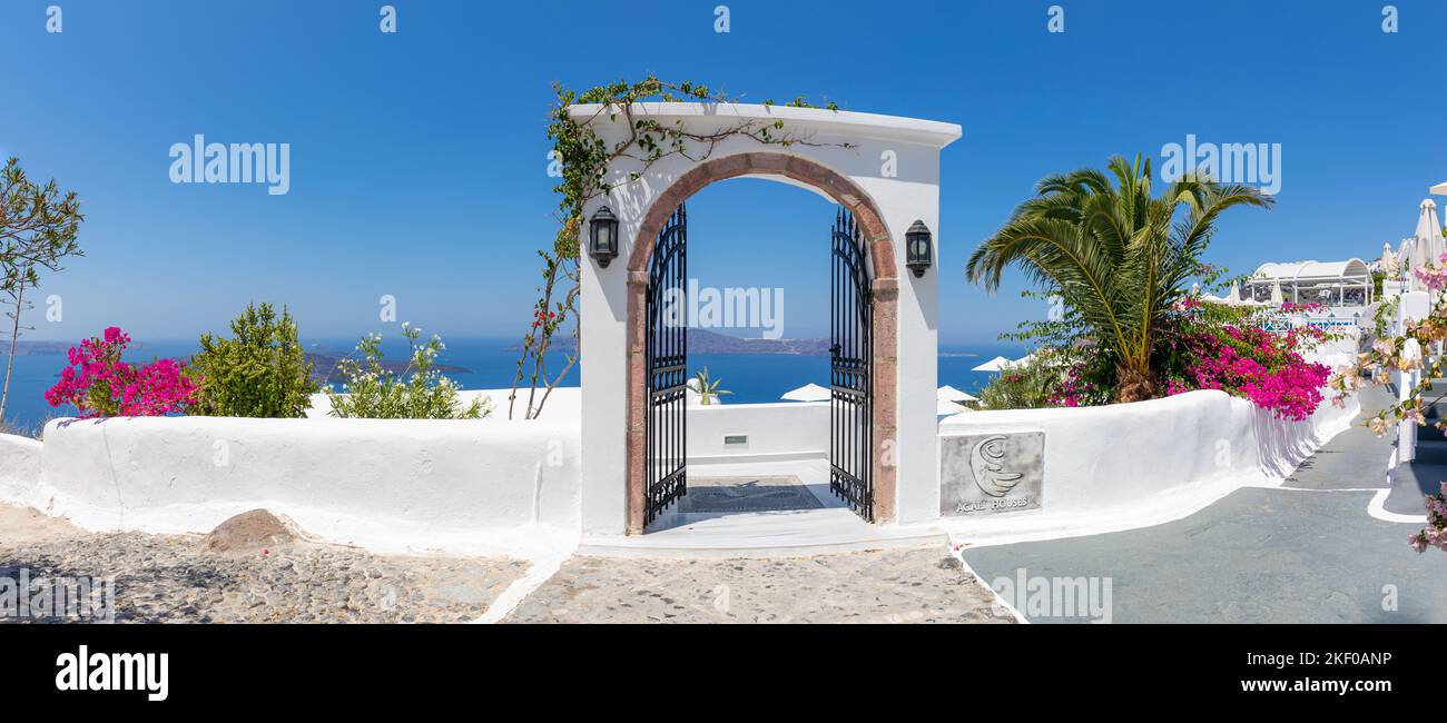 Panorama di viaggio fantastico, paesaggio urbano di Santorini Street. Scale porta o cancello e architettura bianca sotto il cielo soleggiato. Vacanza estiva incredibile Foto Stock