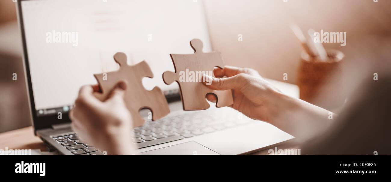 Donna che tiene pezzi di puzzle in ufficio Foto Stock