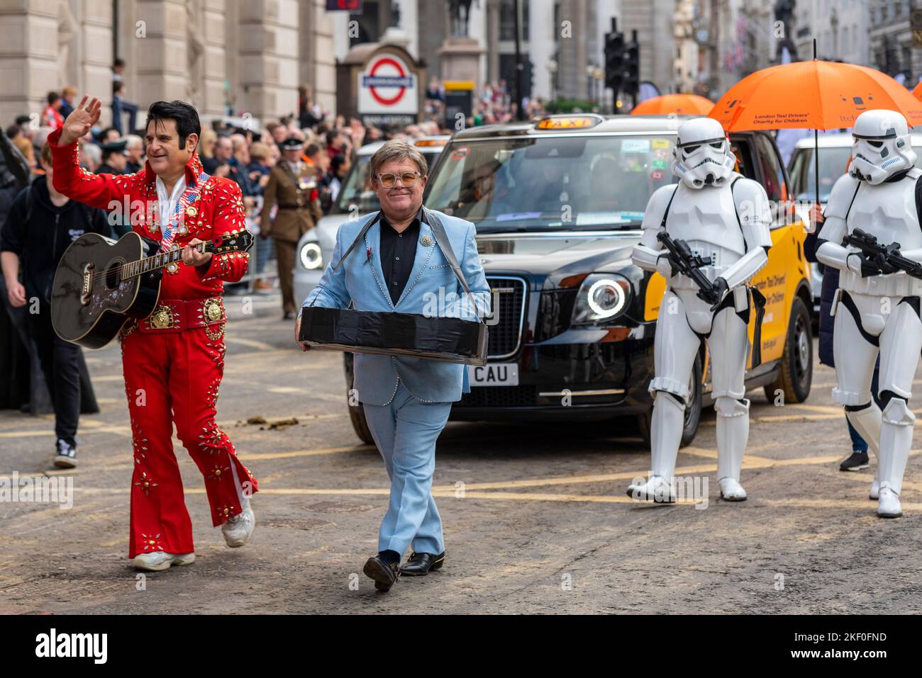 BENEFICENZA DEI TASSISTI DI LONDRA PER I BAMBINI alla sfilata del Lord Mayor's Show nella City of London, Regno Unito. Partecipanti lookalike Foto Stock