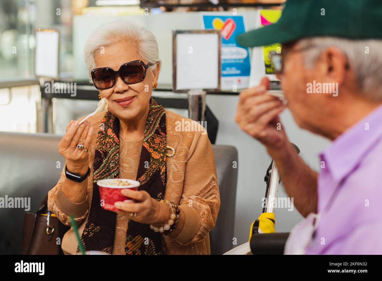 Felice coppia anziana godere di mangiare gelato. Foto Stock