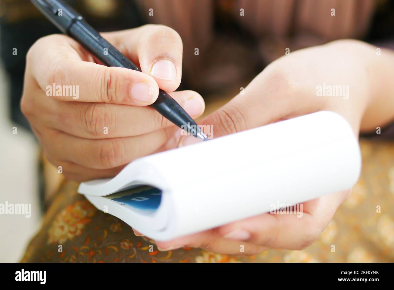 Primo piano di donne mano scrivere su blocco note. Foto Stock