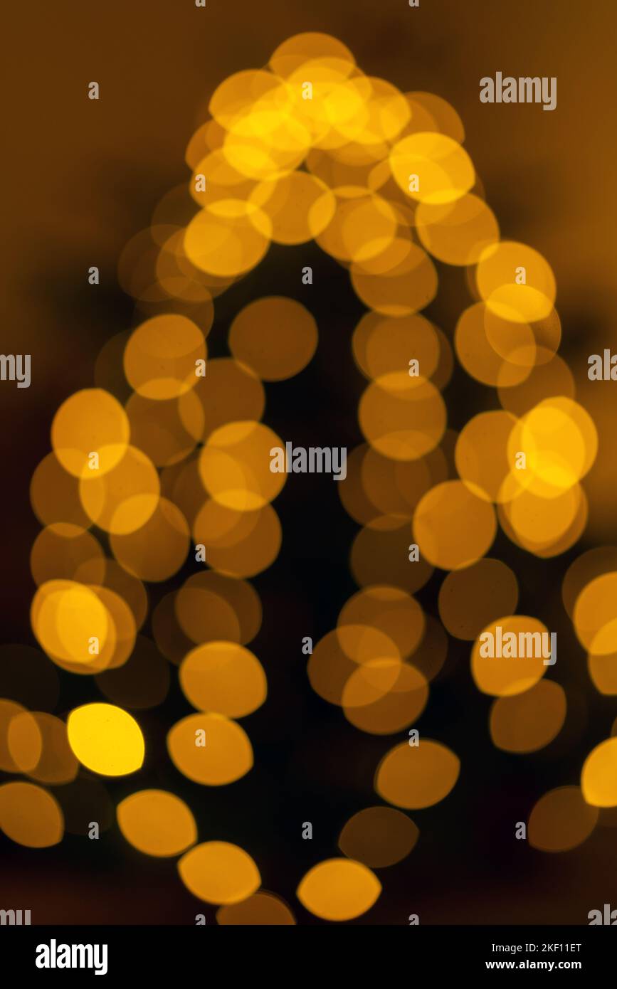 Luci di Natale sfocate sull'albero di Natale. Pino decorato con una ghirlanda luminosa. Foto Stock