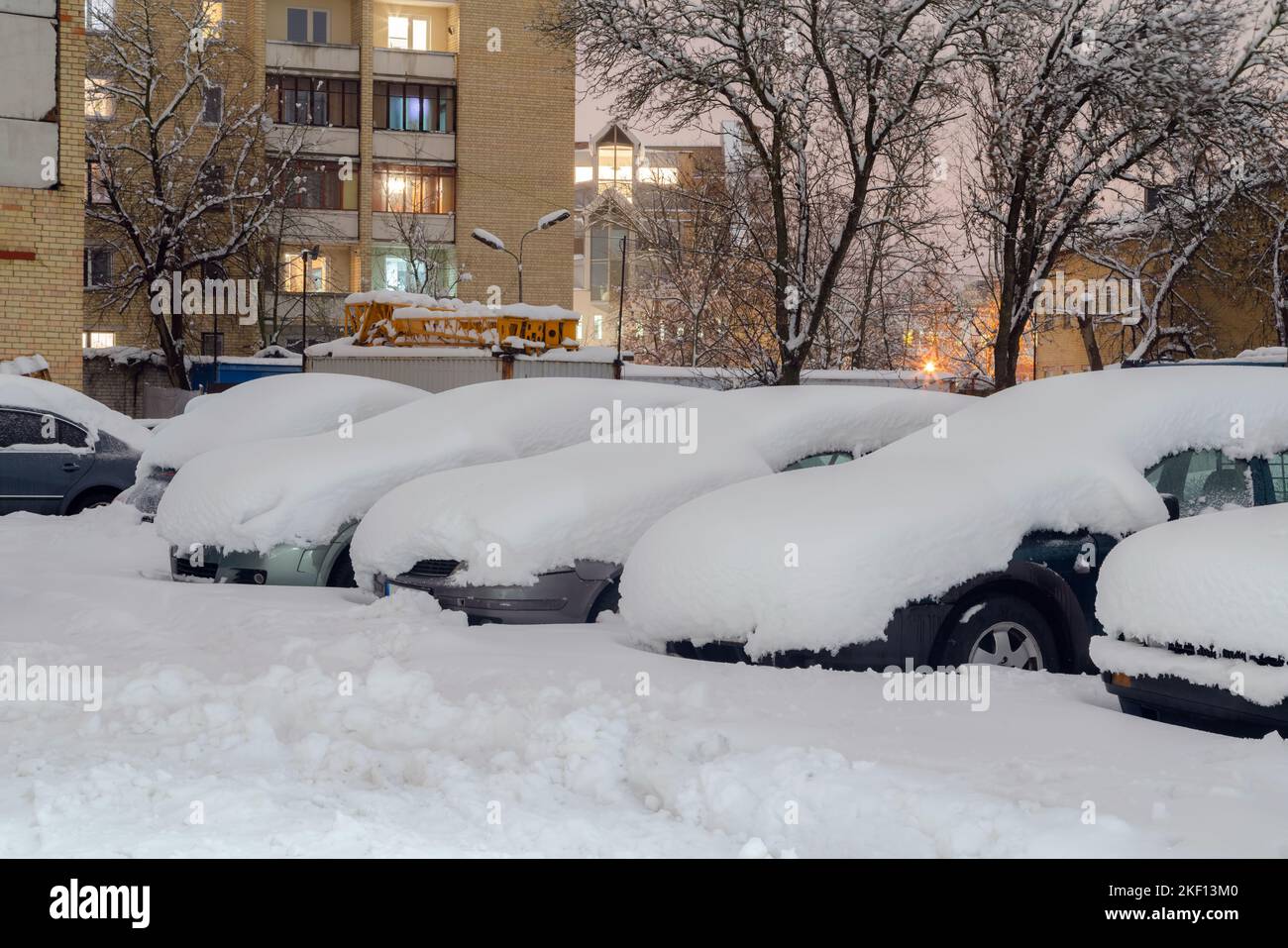 Auto coperta con spesso strato di neve. Automobile dopo la tempesta di neve parcheggiata sul lato della strada. Foto Stock