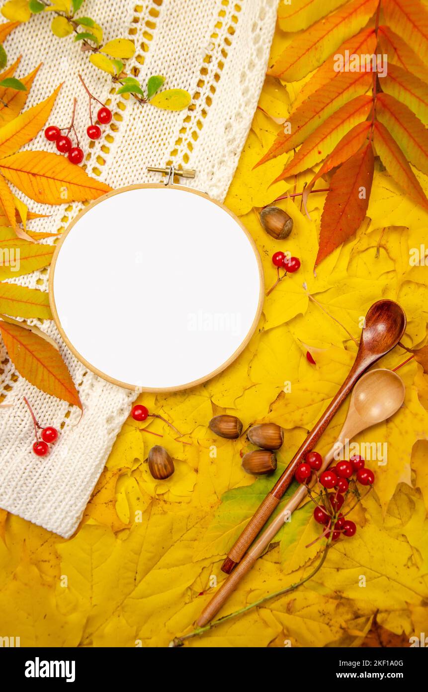 Primo piano mockup verticale di cerchi da ricamo su fondo in giallo arancio tonalità rosso: Cucchiai di frutti di bosco a maglia bianca Foto Stock