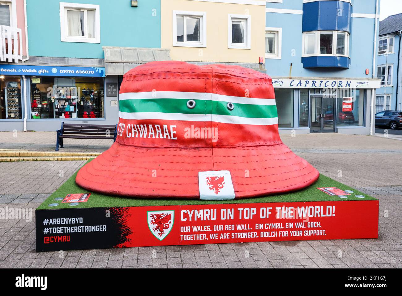 Aberystwyth, Galles, Regno Unito. 15th Nov 2022. Giganteschi e iconici tifosi gallesi a forma di cappello, Aberystwyth, Galles, Regno Unito. Grande, dieci piedi per dieci piedi, installazione d'arte, in esposizione nel centro di Aberystwyth il cappello della benna è diventato un simbolo dei ventilatori della squadra di calcio del Galles. La statua è stata eretta, ci sono cinque nelle città gallesi, per celebrare il Galles Mens nazionale raggiungere le finali della Coppa del mondo per la prima volta dal 1958, un periodo di 64 anni da quando hanno giocato l'ultima volta nella Coppa del mondo. Credit: Paul Quayle/Alamy Live News Foto Stock