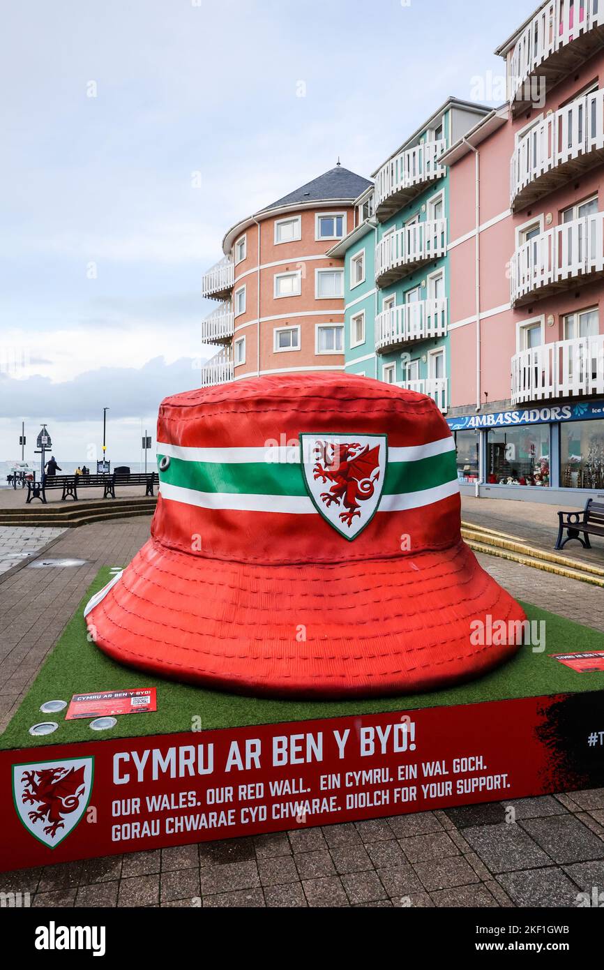 Aberystwyth, Galles, Regno Unito. 15th Nov 2022. Giganteschi e iconici tifosi gallesi a forma di cappello, Aberystwyth, Galles, Regno Unito. Grande, dieci piedi per dieci piedi, installazione d'arte, in esposizione nel centro di Aberystwyth il cappello della benna è diventato un simbolo dei ventilatori della squadra di calcio del Galles. La statua è stata eretta, ci sono cinque nelle città gallesi, per celebrare il Galles Mens nazionale raggiungere le finali della Coppa del mondo per la prima volta dal 1958, un periodo di 64 anni da quando hanno giocato l'ultima volta nella Coppa del mondo. Credit: Paul Quayle/Alamy Live News Foto Stock