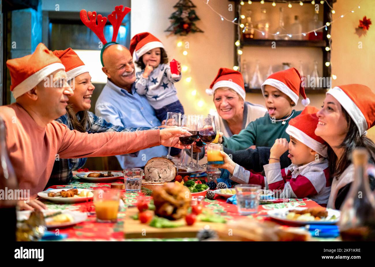 Grande famiglia multi generazione brinda al festival di Natale della cena - Natale di festa di inverno concetto con i grandi genitori e bambini che mangiano insieme nel paese Foto Stock