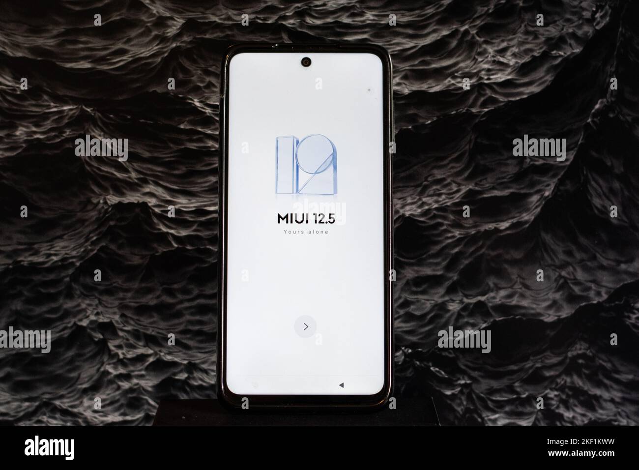 Primo piano di uno smartphone XIAOMI NOTE 9 PRO e del logo software MIUI 12,5 scritto su un display bianco, su uno sfondo artistico nero Foto Stock