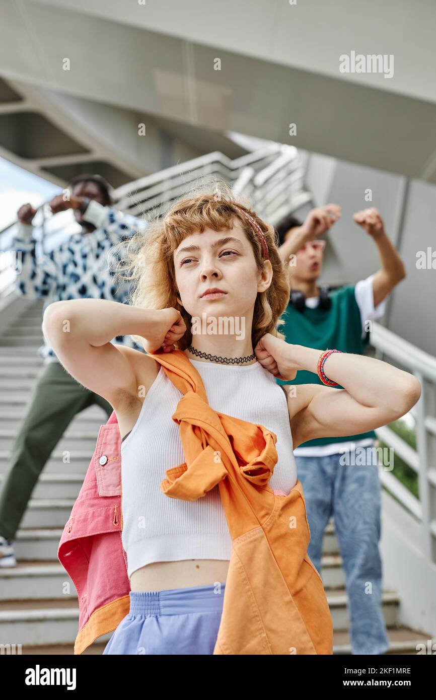 Ritratto verticale della giovane squadra di Street dance con attenzione alla giovane donna in primo piano Foto Stock