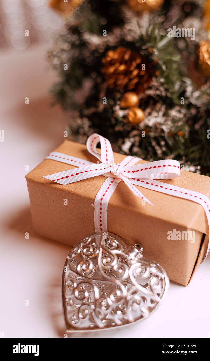 Decorativi alberi di Natale e scatole regalo su tavolo di legno contro luci sfocate Foto Stock