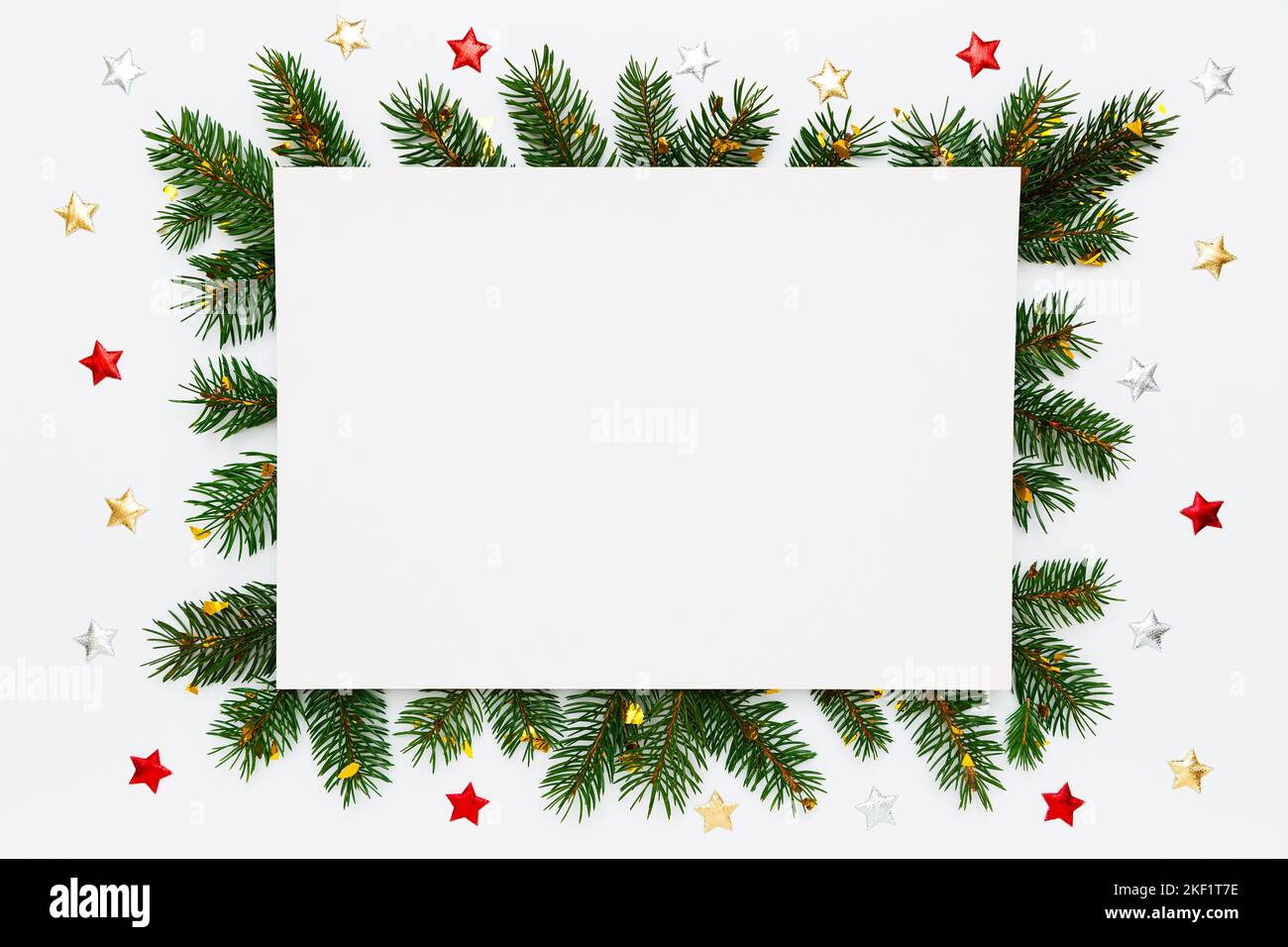 Layout Natale, Capodanno con spazio per testo. Carta bianca in cornice di rami di abete naturale e decorazioni su giacitura bianca piatta Foto Stock