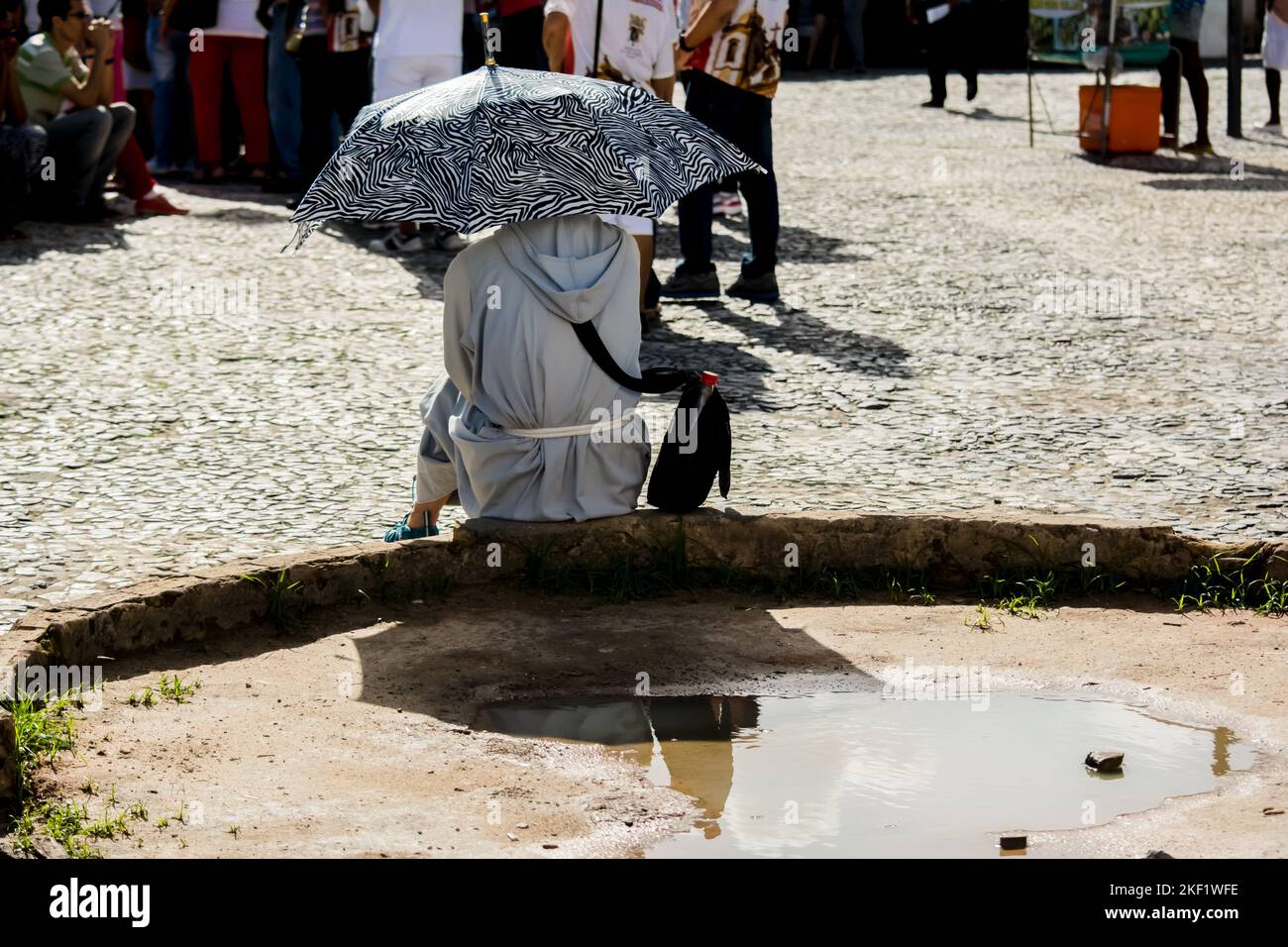 Salvador, Bahia, Brasile - 26 maggio 2016: Un frate cattolico è seduto sulla strada durante la messa di Cristo corpus, nella città di Salvador, Brasile. Foto Stock
