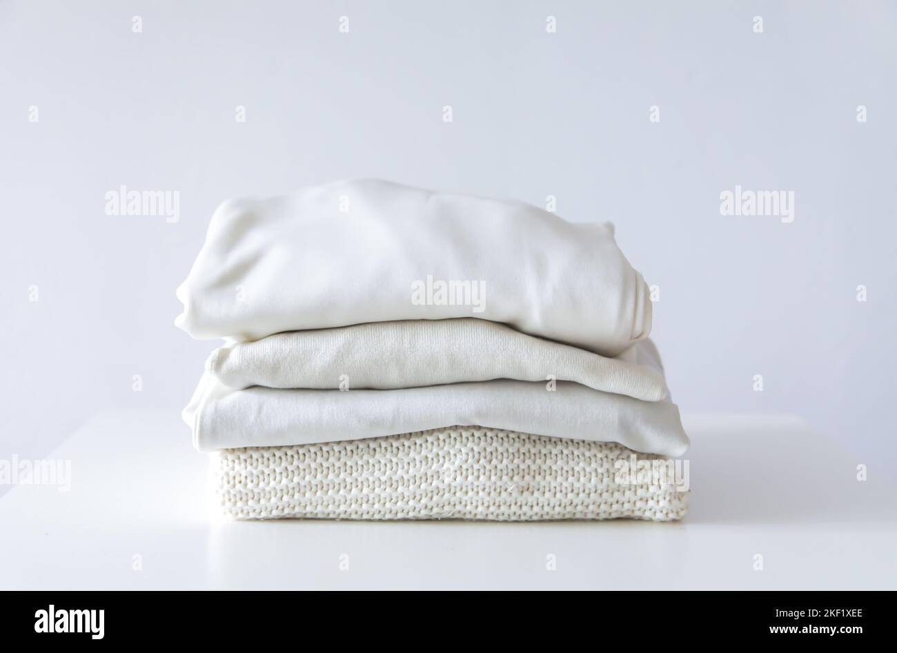 Pila di vestiti colorati piegati. Custodia compatta per l'organizzazione in casa. Foto Stock