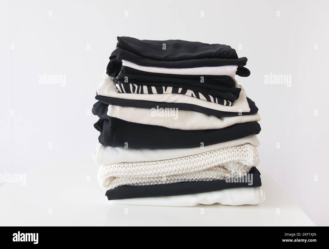 Pila di vestiti colorati piegati. Custodia compatta per l'organizzazione in casa. Foto Stock