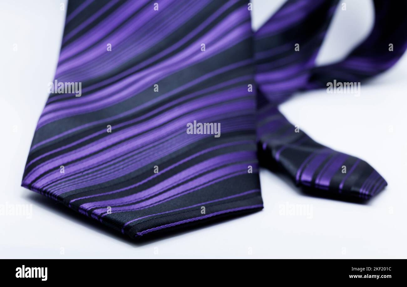 cravatta con strisce viola e nera su sfondo bianco Foto Stock