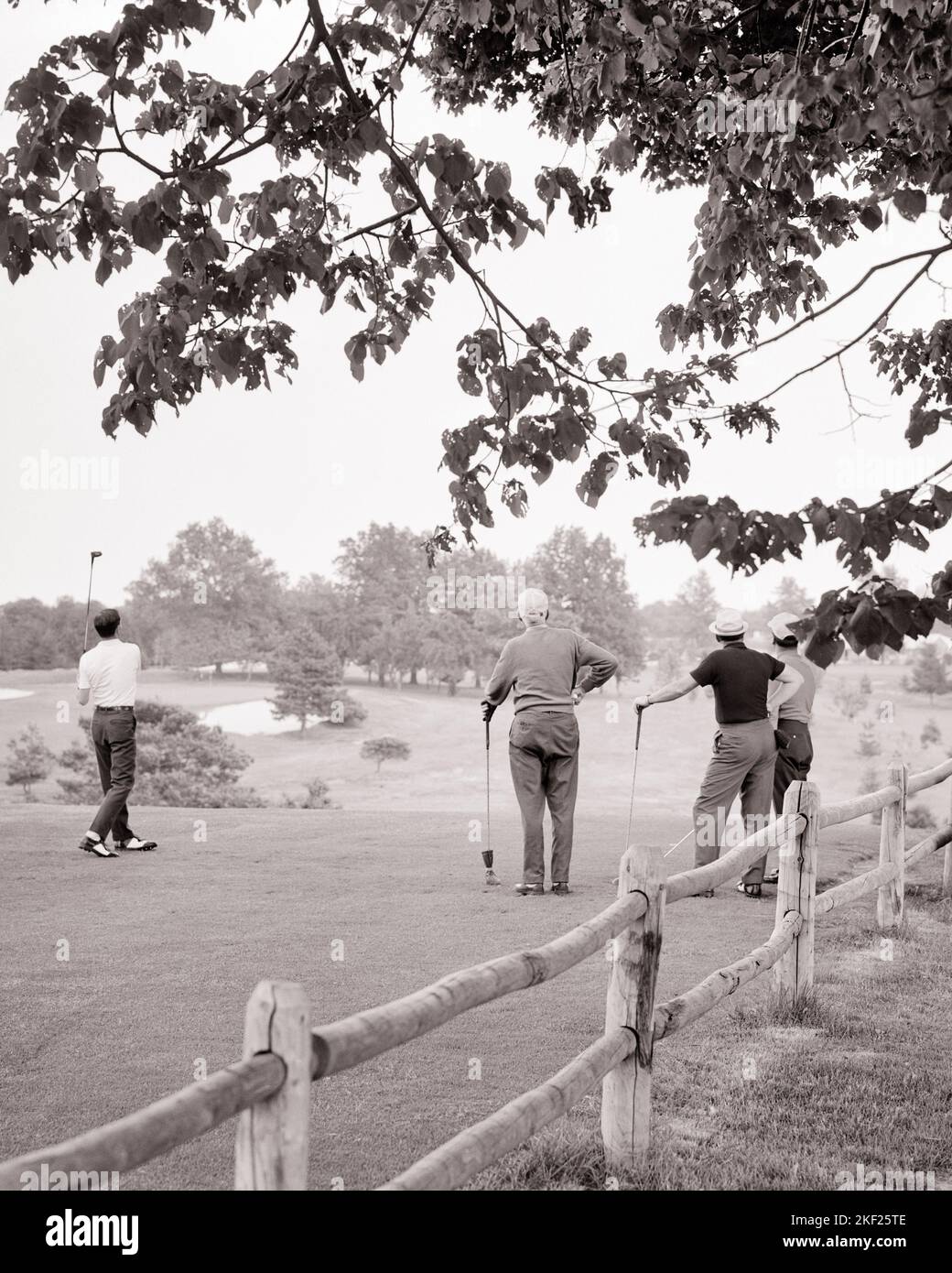 1960S 1970S VISTA POSTERIORE DI GRUPPO DI UOMINI A TEE OFF SPOT CON UN UOMO SOLO COMPLETARE LA SUA OSCILLAZIONE - G7131 HAR001 HARS TEE COPY SPAZIO AMICIZIA FISICA FITNESS PERSONE MASCHI SOLO GOLF SPOT CLUB B&W DI MEZZA ETÀ OBIETTIVI UOMO DI MEZZA ETÀ ATTIVITÀ GOLFERS LA SUA FORZA DI SVAGO RICREAZIONE FAIRWAY VISTA POSTERIORE DA DIETRO FUGA FLESSIBILITÀ AMICHEVOLE COLLEGAMENTI MUSCOLI COMPLETANDO PADRI E FIGLI INDIETRO VISTA COOPERAZIONE UOMO MEDIO-ADULTO MEDIO-ADULTO TOGETHERNESS GIOVANE UOMO ADULTO GIOVANE ADULTO NERO E BIANCO ETNICITÀ CAUCASICA CAMPO DA GOLF HAR001 VECCHIO STILE Foto Stock