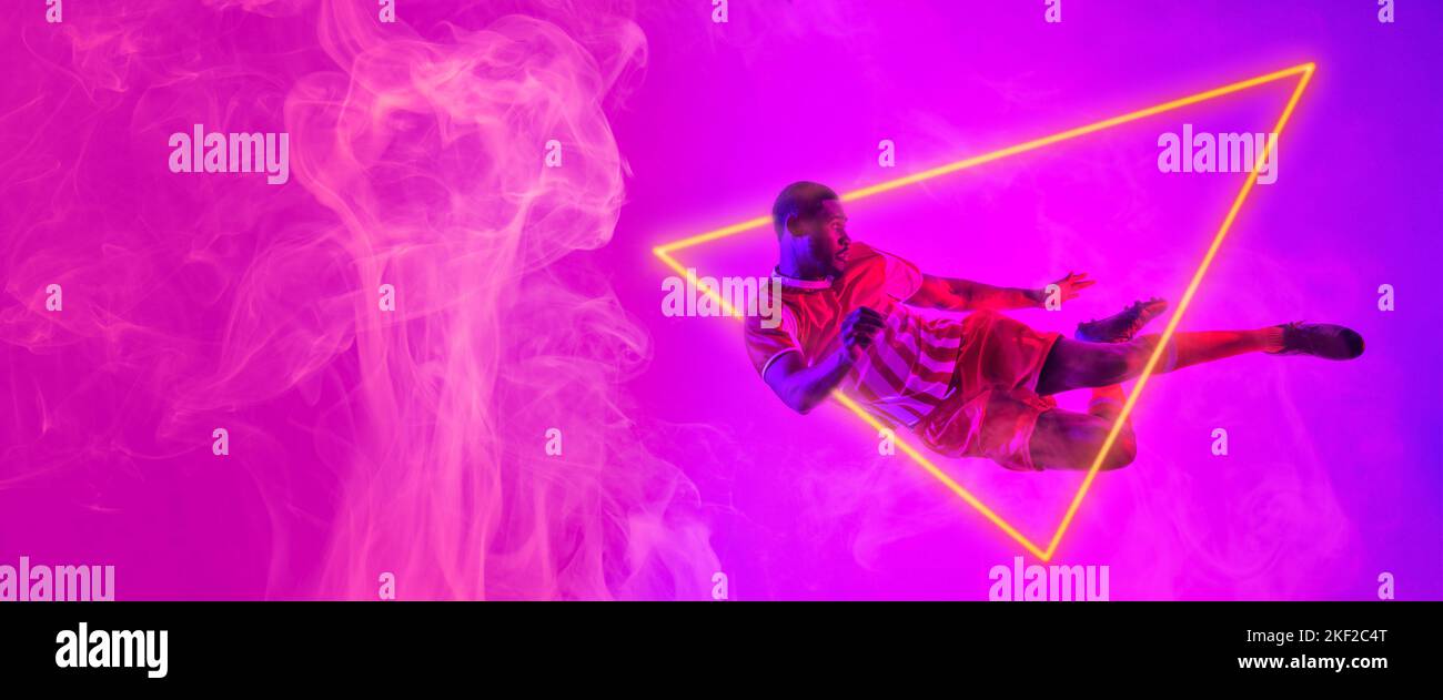 Giocatore afro-americano di calcio maschile saltando da triangolo illuminato, copia spazio Foto Stock Giocatore afro-americano di calcio maschile saltando da triangolo illuminato, copia spazio Foto Stock