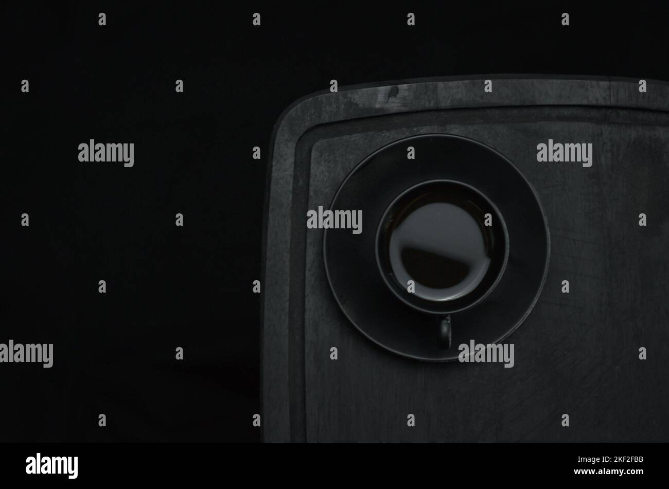 Caffè italiano. Tazza di espresso caldo, moka pot su un asse di legno rustico, sfondo scuro, messa a fuoco selettiva. Natura morta, fotografia scura. Foto Stock