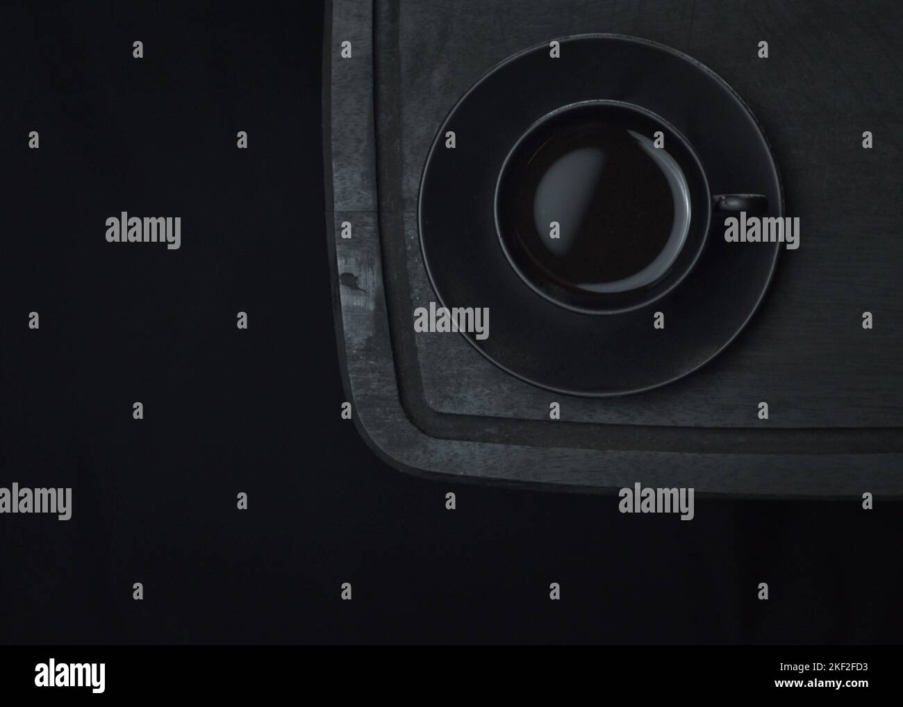 Caffè italiano. Tazza di espresso caldo, moka pot su un asse di legno rustico, sfondo scuro, messa a fuoco selettiva. Natura morta, fotografia scura. Foto Stock