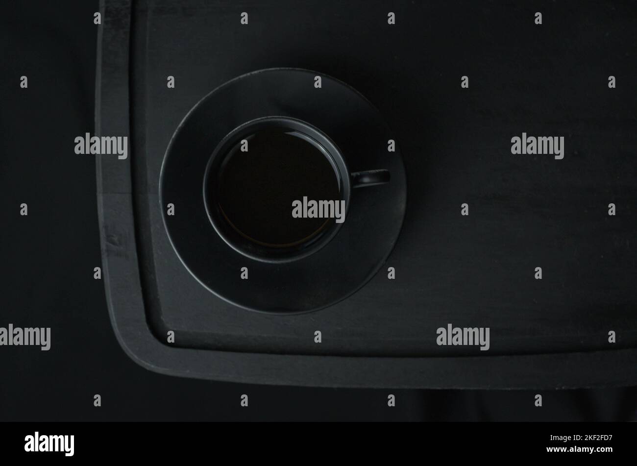 Caffè italiano. Tazza di espresso caldo, moka pot su un asse di legno rustico, sfondo scuro, messa a fuoco selettiva. Natura morta, fotografia scura. Foto Stock