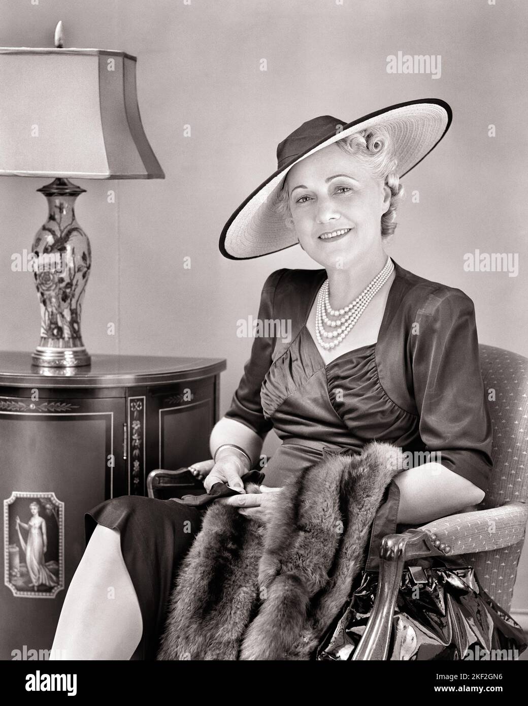 1940S ATTRAENTE DONNA DI MEZZA ETÀ CHE INDOSSA BIG HAT PEARL ABITO IN RASO CHE TIENE CODA FOX STOLE SEDUTA IN SEDIA GUARDANDO LA MACCHINA FOTOGRAFICA - S4230 HAR001 HARS RICCO PIACERE GIOIA LIFESTYLE DONNE ANZIANE STUDIO SHOT HOME VITA LUSSO COPIA SPAZIO FULL-LENGTH SIGNORE PERSONE SATIN FOX PENSIONAMENTO CODA FIDUCIA MEDIO-ETÀ B & W OCCHIO CONTATTO PENSIONATI FELICITÀ MEDIO-ETÀ DONNA STILI ALLEGRI RICCHEZZA SORRIDE ANZIANI DI ALTO LIVELLO STOLE LOVELY AFFLUENT GIOIOSO ELEGANTE ATTRAENTE ABITI BEN-TO-DO NERO E BIANCO CAUCASICO ETNICITÀ HAR001 VECCHIO STILE Foto Stock