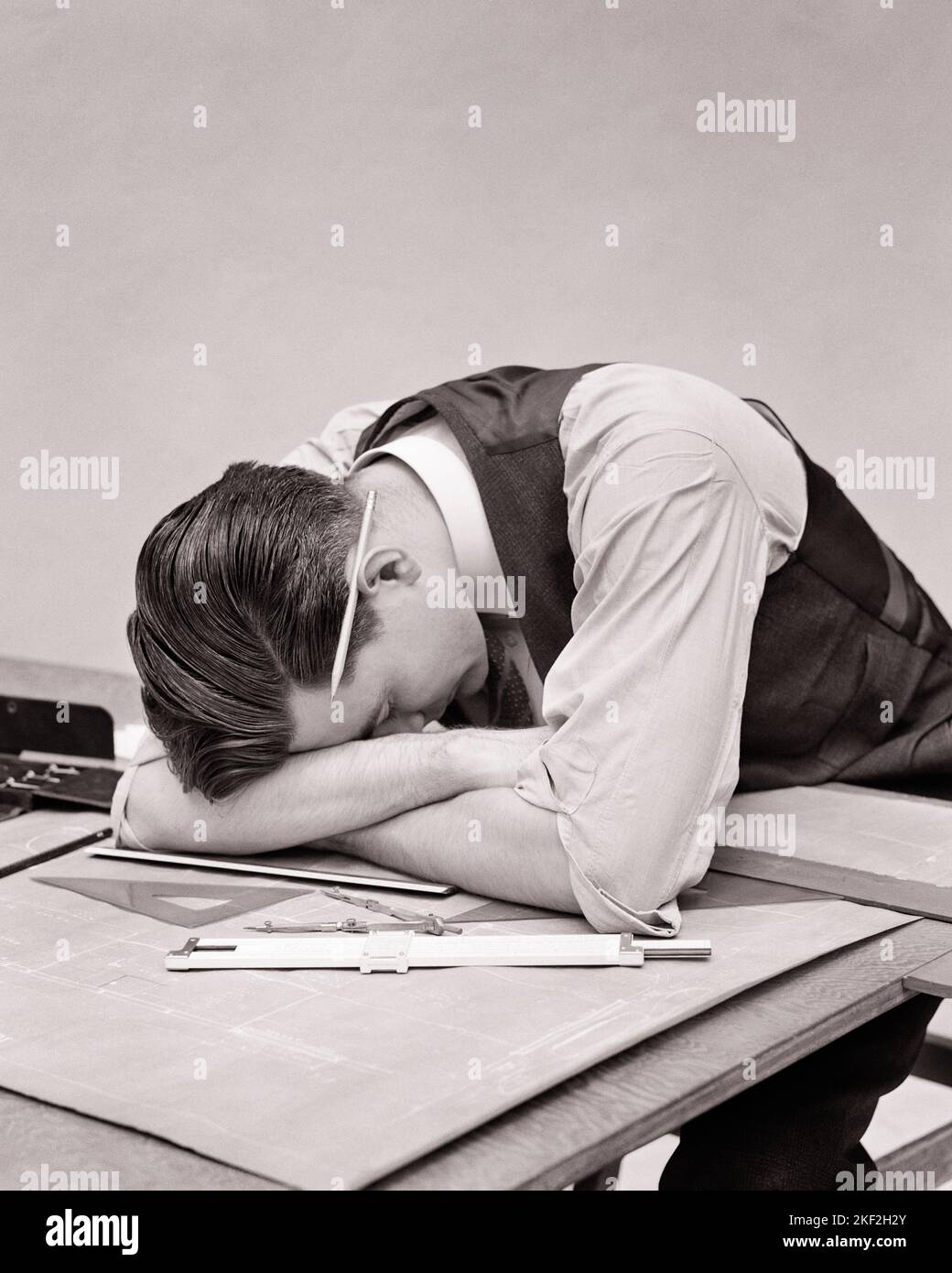 1930S SFINITO DISEGNATORE SOVRACCARICANTE CHE APPOGGIA LA TESTA SULLE BRACCIA SU UN TAVOLO DA DISEGNO COPERTO DI MATITA BLUEPRINTS DIETRO L'ORECCHIO - S8389 HAR001 HARS DISTURBI PROFESSIONE TRAVAGLIATO B&W PREOCCUPATO TRISTEZZA OCCUPAZIONE SOFFERENZA CARRIERE LAVORO UMORE OCCUPAZIONI GLUM DIPENDENTE SCARSA SALUTE MID-ADULT MID-ADULT MALE UOMO NERO E BIANCO CAUCASICO ETNIA HAR001 LAVORARE VECCHIO STILE Foto Stock