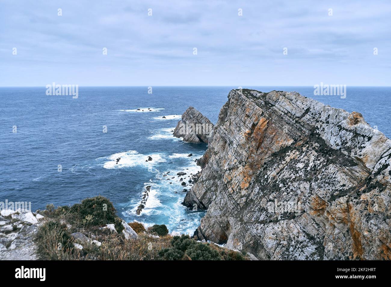 scogliera con grandi rocce sulla costa solitaria vicino al mare in un luogo tranquillo una giornata nuvolosa, cabo de penas, spagna Foto Stock