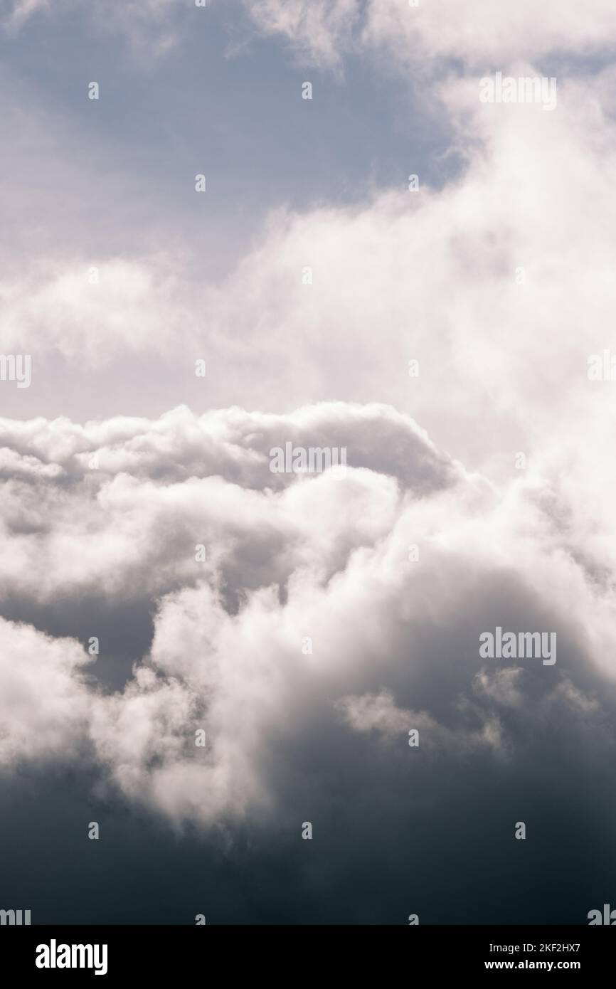Heavenly rottura nelle nuvole grigie sopra il Galles. Varco nelle nuvole che mostrano il cielo blu e le nuvole bianche lanuginose. Una finestra sul cielo. Foto Stock