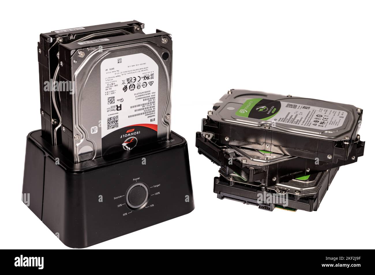 Una pila di tre dischi rigidi accanto a un compartimento del disco rigido Foto Stock