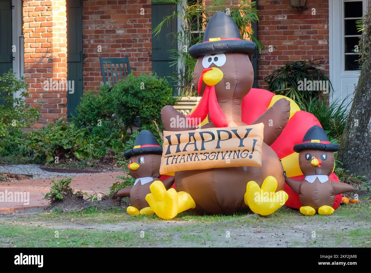 NEW ORLEANS, LA, USA - 11 NOVEMBRE 2022: Tacchini gonfiabili in costumi da pellegrino con il cartello Happy Thanksgiving di fronte all'Uptown Building Foto Stock
