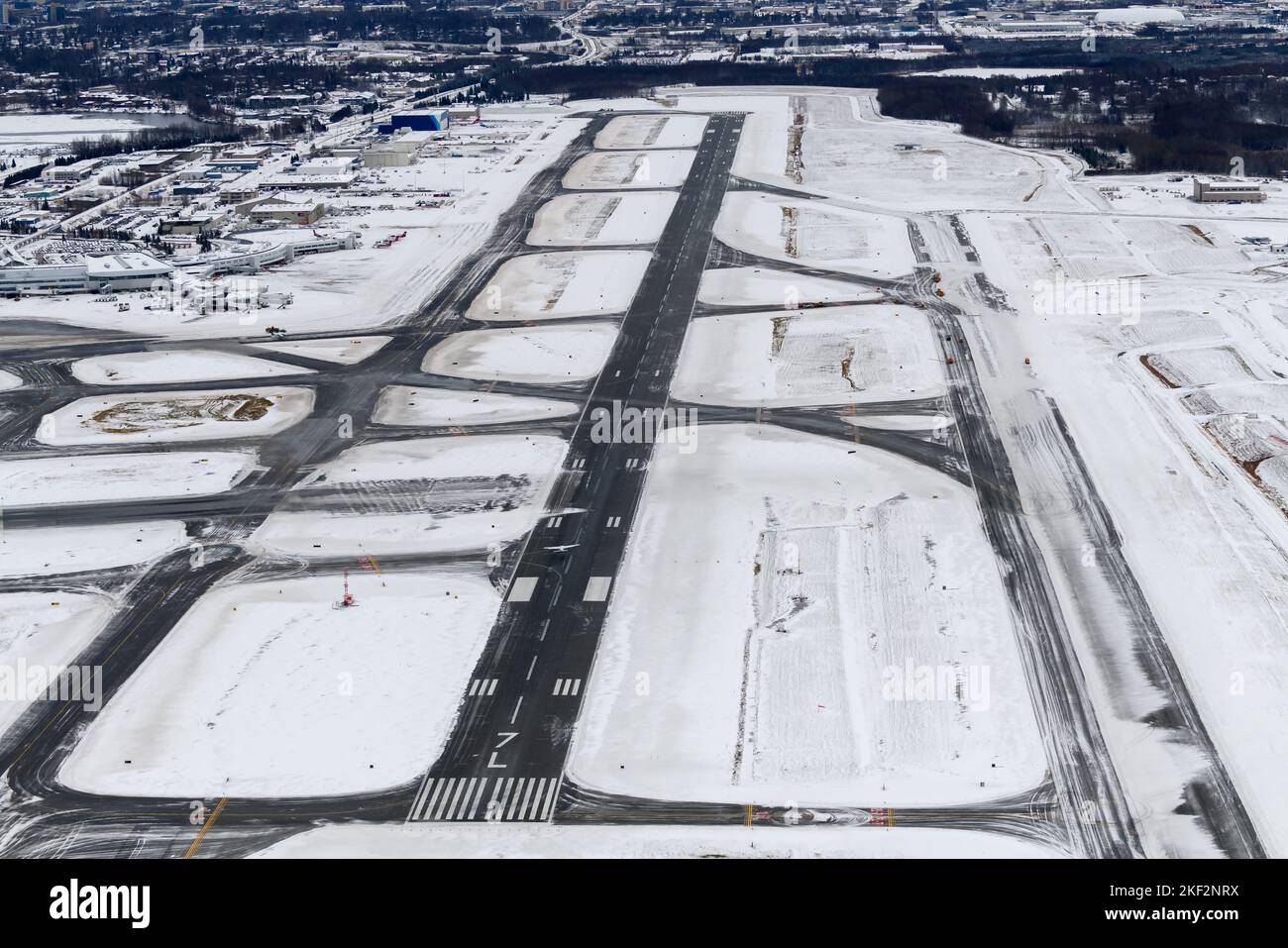 Panoramica della pista dell'aeroporto di Anchorage Ted Stevens dopo una caduta di neve. Operazioni invernali all'aeroporto presso il centro merci di Anchorage. Rimozione della neve dalla pista. Foto Stock