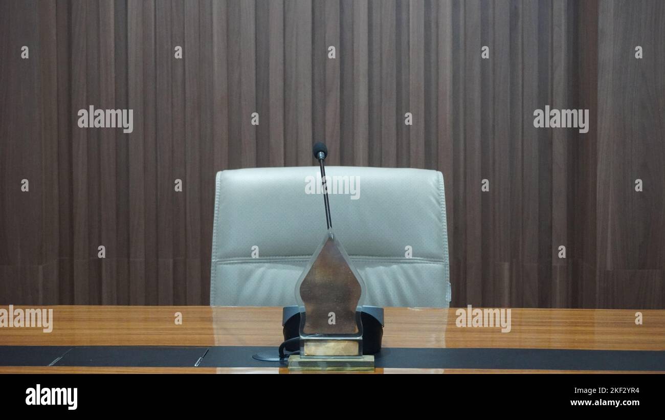 Tavolo interno, sedie e microfono con caffè nella sala riunioni o in ufficio Foto Stock