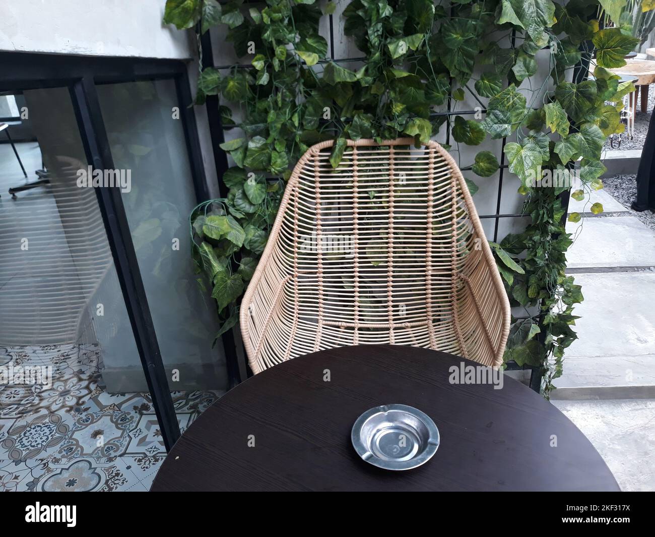 Design interno un tavolo da caffè e sedie con pavimenti in pietra e decorazioni in pianta alle pareti Foto Stock Design interno un tavolo da caffè e sedie con pavimenti in pietra e decorazioni in pianta alle pareti Foto Stock