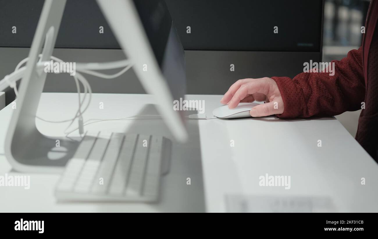 La ragazza lavora su un grande personal computer bianco. Primo piano Foto Stock