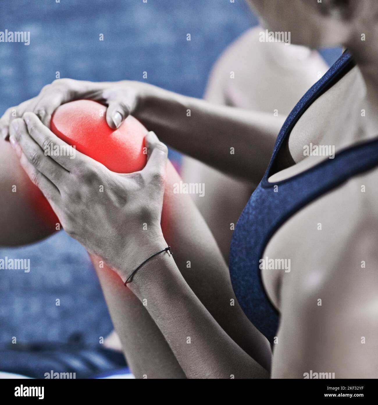Una giovane donna che tiene il ginocchio ferito ha evidenziato in rosso. Foto Stock