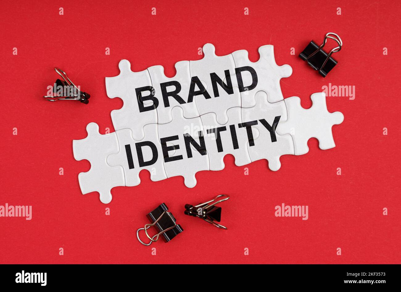 Business ed Economia. Su uno sfondo rosso, ci sono puzzle con l'iscrizione - Brand Identity Foto Stock