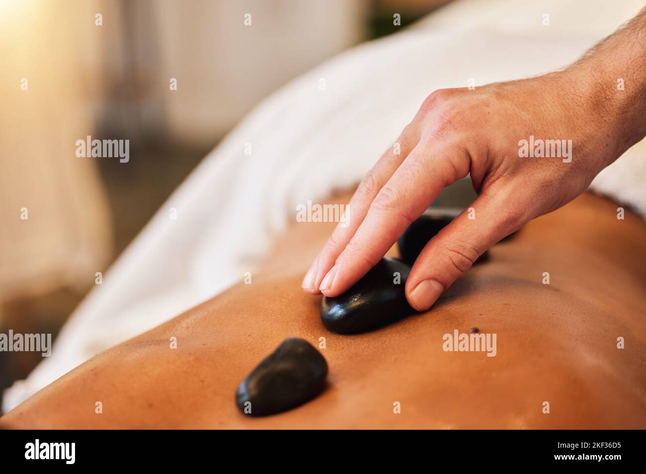 Massaggio con pietre calde, spa e cura della pelle per il benessere, la salute e la terapia fisica per rilassarsi nel lusso. Mente, corpo e spirito benessere con rock terapia Foto Stock