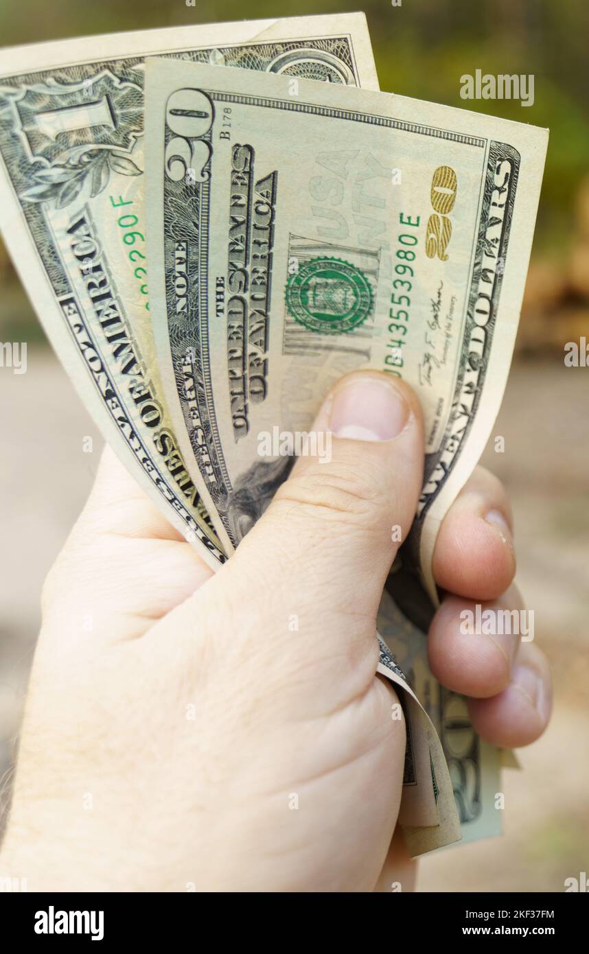 Concetto aziendale. Un uomo tiene 20 e 1 dollari fatture nelle sue mani. Foto Stock