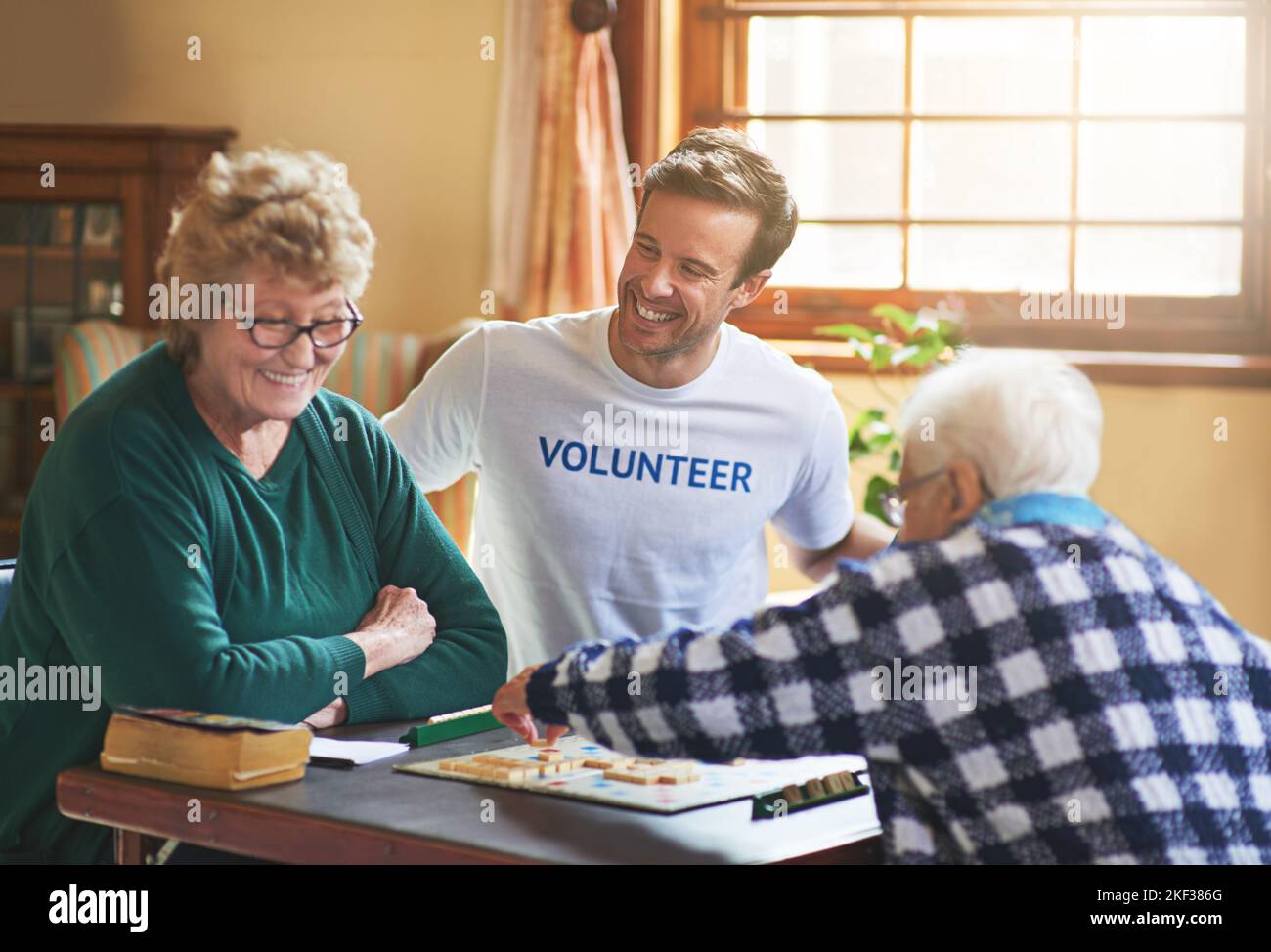 Ci si sente bene fare del bene. Un volontario che lavora con gli anziani in una casa di riposo. Foto Stock