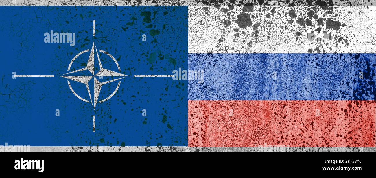 Bandiere della NATO e della Russia sul muro con una grande spaccatura al centro. Le relazioni tra l'Organizzazione del Trattato del Nord Atlantico e. Foto Stock