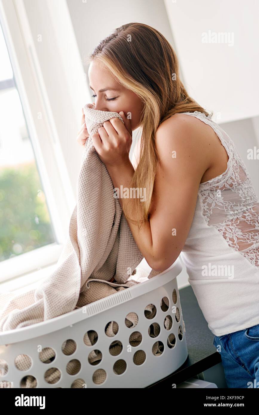 Il suo giorno di lavanderia. Giovane donna che fa il bucato a casa. Foto Stock